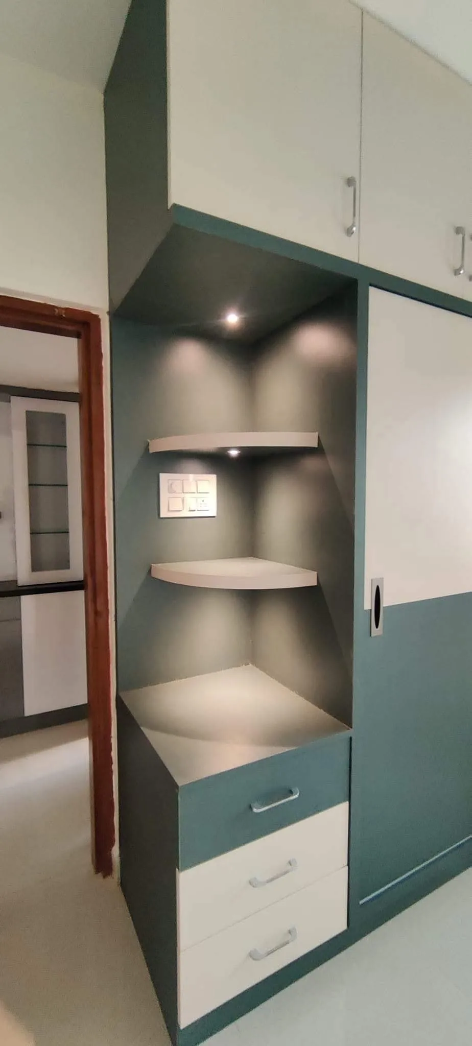 Corner display shelves with teal accent wall